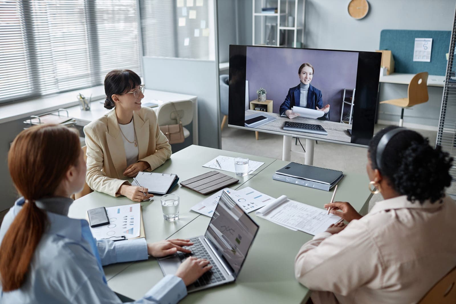 Three colleagues on a video call reviewing the month together